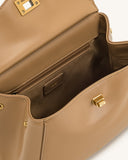 Light brown faux leather top handle bag, open to reveal a dark brown interior with a zippered pocket and gold-toned twist-loc