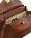 Open brown faux leather bag with a flap closure, gold-toned turn-lock, and an interior zipper pocket.