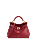 Red faux leather top handle bag with a rounded handle, gold-toned turn-lock closure, and a thin shoulder strap.