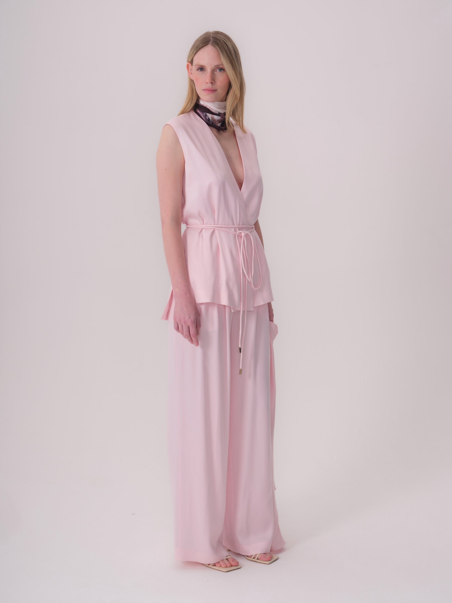 Pink, wide-leg trousers made of a soft, flowy fabric, with a full-length hem.