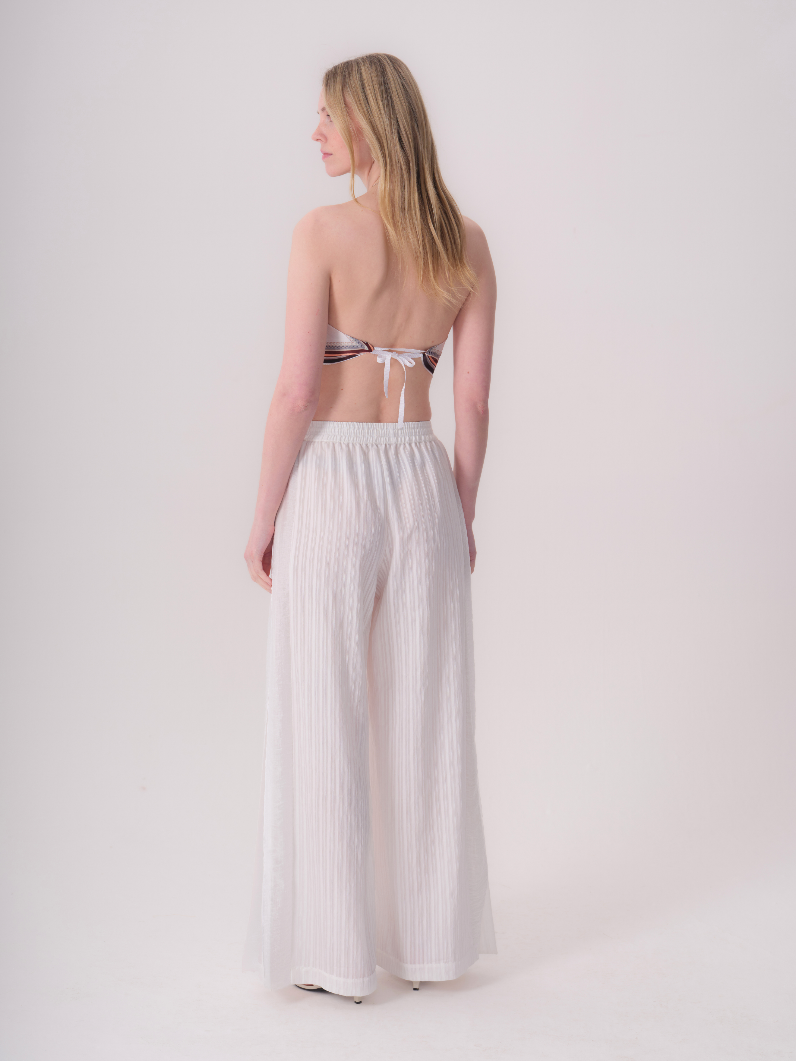 White wide-leg trousers with an elasticated waistband and vertical textured stripes.