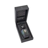 Black textured box with a dark multi-faceted perfume bottle. Bottle has a blue-green to black gradient, gold-toned cap, and L