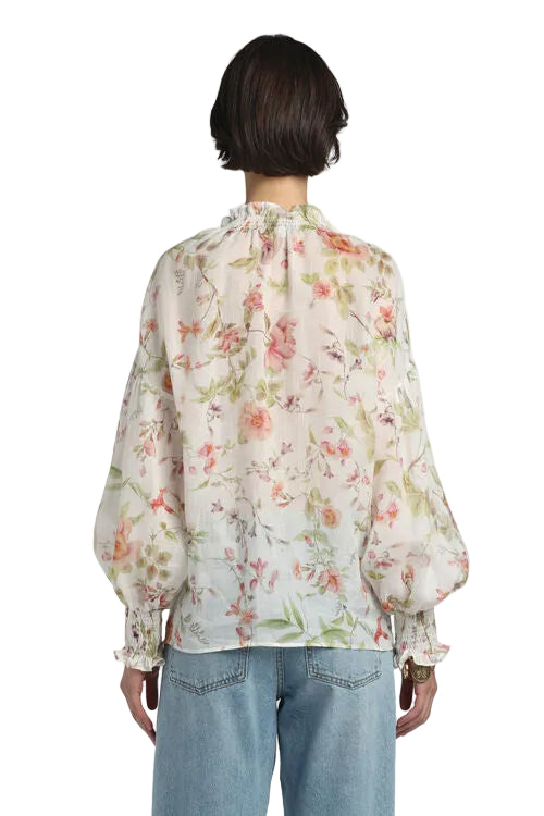 Off-white floral blouse with peach roses and green leaves, ruffled high neck, and smocked balloon sleeves.