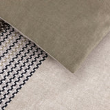 Duvet cover set featuring sections of solid light olive green, black, white, and tan houndstooth, and solid light beige fabri