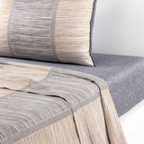 Bedding set: gray fitted sheet, and a duvet cover with pillow featuring horizontal white, gold-toned, and gray stripes with d