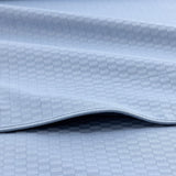 Light blue fabric with a subtle woven checkered pattern and a visible stitched hem.