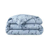 Light blue duvet cover with a pattern of small dark blue and white stylized leaves, folded neatly.