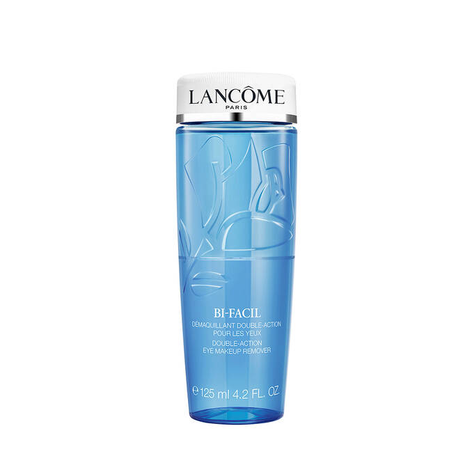 Clear plastic bottle of Lancome Bi-Facil eye makeup remover with blue liquid, white cap, and embossed floral design.