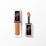 Lancome Idole Tint in a clear rectangular bottle with a rose gold-toned cap, next to its black doe-foot applicator with warm
