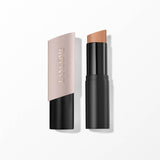 Lancome foundation stick with a light pink angled cap featuring gold-toned text, and a black base revealing an angled tan fou