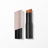 Lancome Tiu Stick Foundation in a medium caramel shade, with a matte black base and an angled light beige cap.