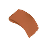 A curved swatch of matte, medium reddish-brown foundation with textured edges.