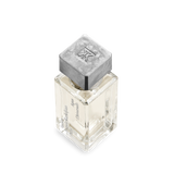 Square clear glass perfume bottle with pale liquid and vertical black text. It has a textured silver-toned square cap with an