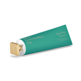 Teal hand cream tube with gold-toned text and a square gold-toned cap featuring an embossed 'K' logo.