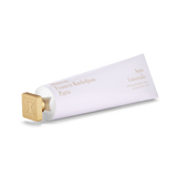 White hand cream tube with a gold-toned square cap embossed with an 'X' logo. Gold text: 'Maison Francis Kurkdjian Paris' and