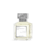 Clear faceted glass perfume bottle with light yellow liquid, a white label, and a textured silver-toned rectangular cap.