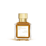 Rectangular clear glass perfume bottle with amber liquid and a shiny gold-toned cap, featuring a white label.
