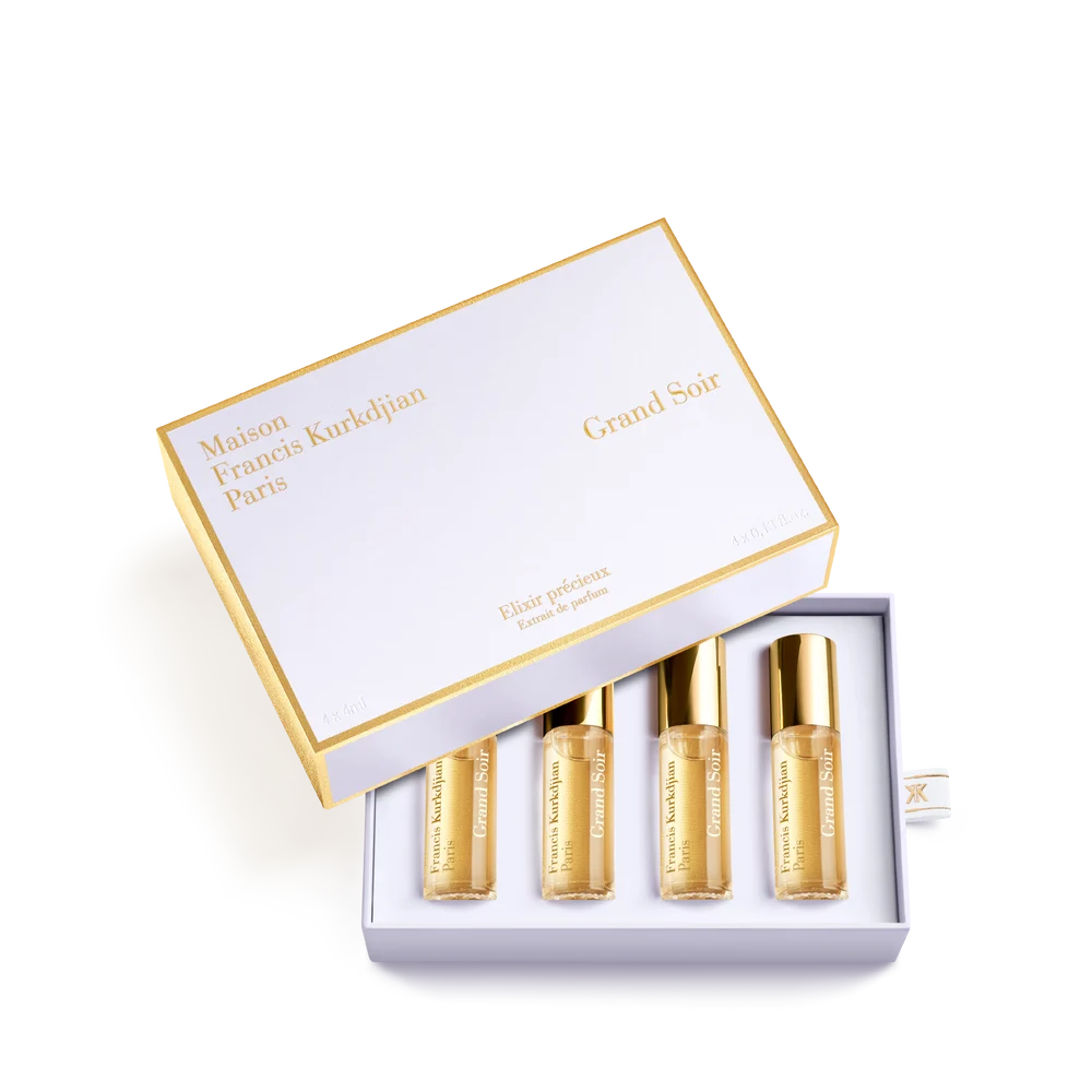 White and gold-toned Maison Francis Kurkdjian Grand Soir roll-on fragrance set with four amber liquid vials.