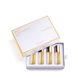 White and gold-toned Maison Francis Kurkdjian Grand Soir roll-on fragrance set with four amber liquid vials.