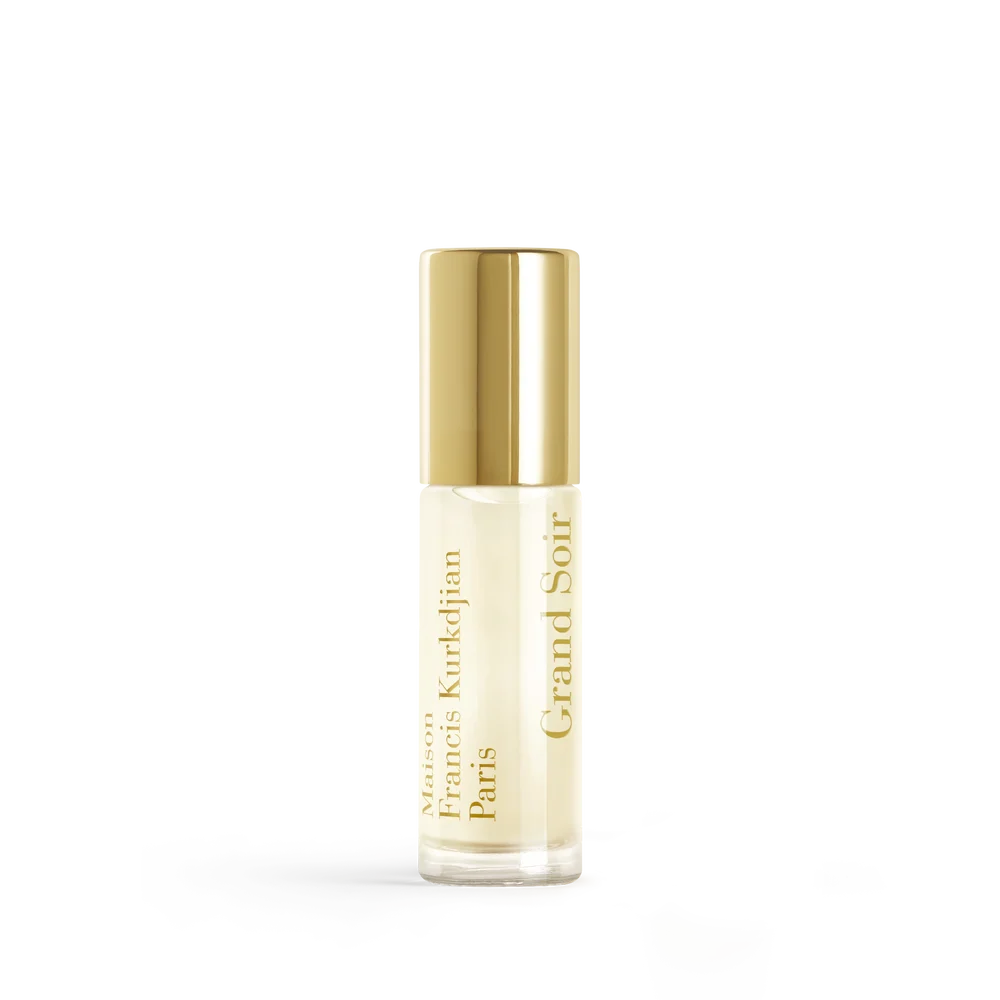 Clear glass roll-on perfume bottle with pale yellow liquid, a shiny gold-toned cap, and vertical gold text.