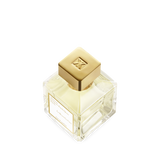 Clear square glass perfume bottle with pale yellow liquid, a gold-toned square cap with an embossed 'FK' logo, and a white la
