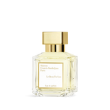 Clear glass perfume bottle with pale yellow liquid, a gold-toned square cap, and a white label with black text.