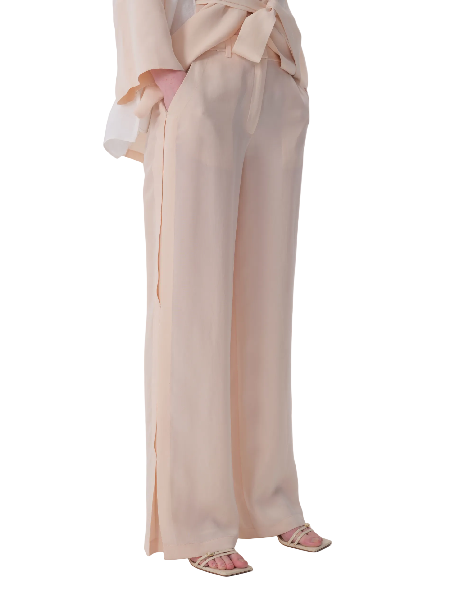 Cream wide-leg trousers with a self-fabric tie-belt, side pockets, and outer leg slits.