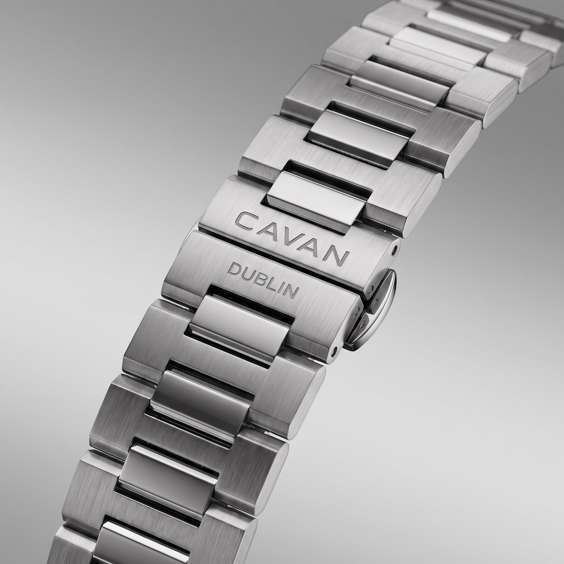 Silver-toned multi-link watch band with brushed and polished finishes. The clasp is engraved with "CAVAN DUBLIN".