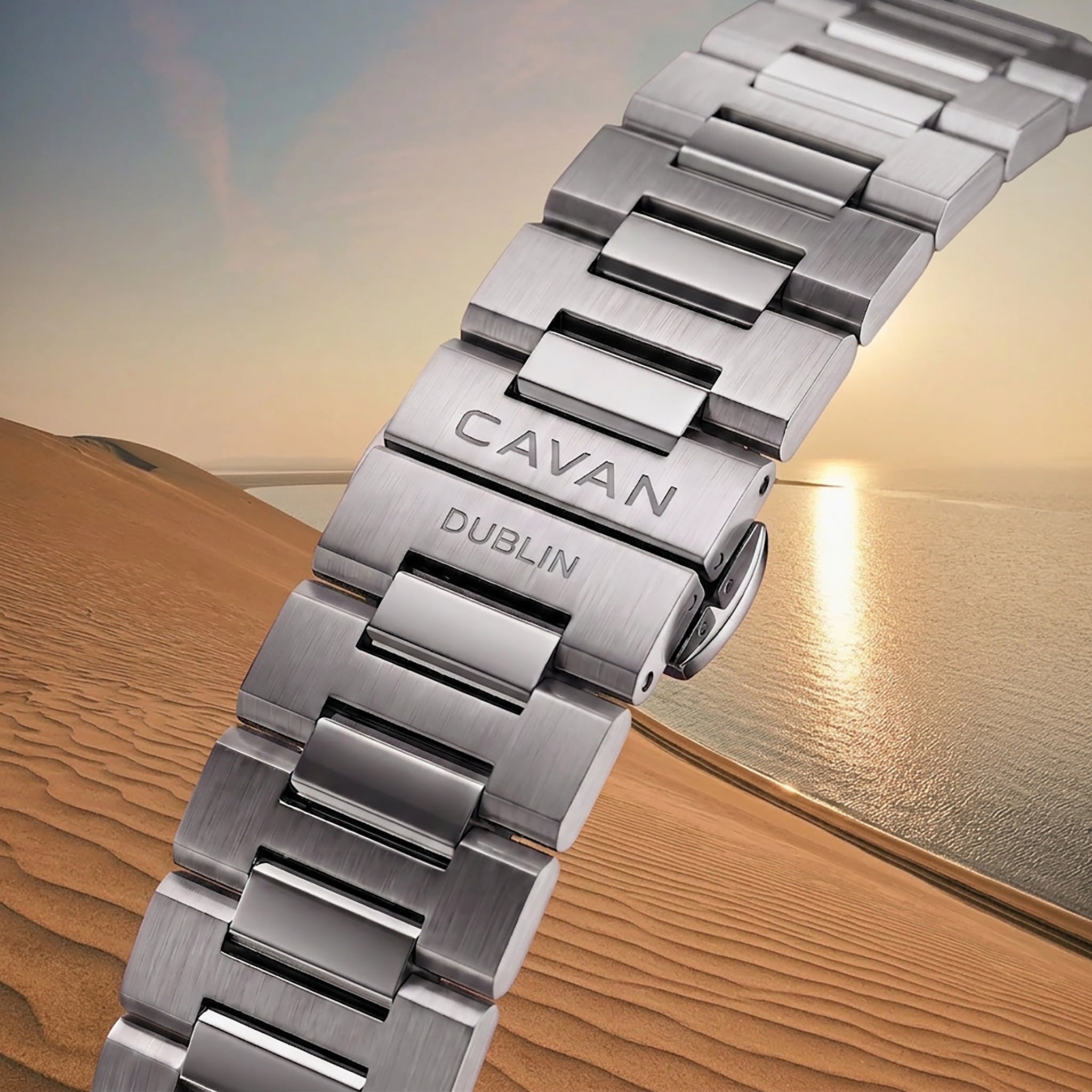 Silver-toned metal watch link bracelet with brushed and polished links. The deployant clasp is engraved with 'CAVAN DUBLIN'.