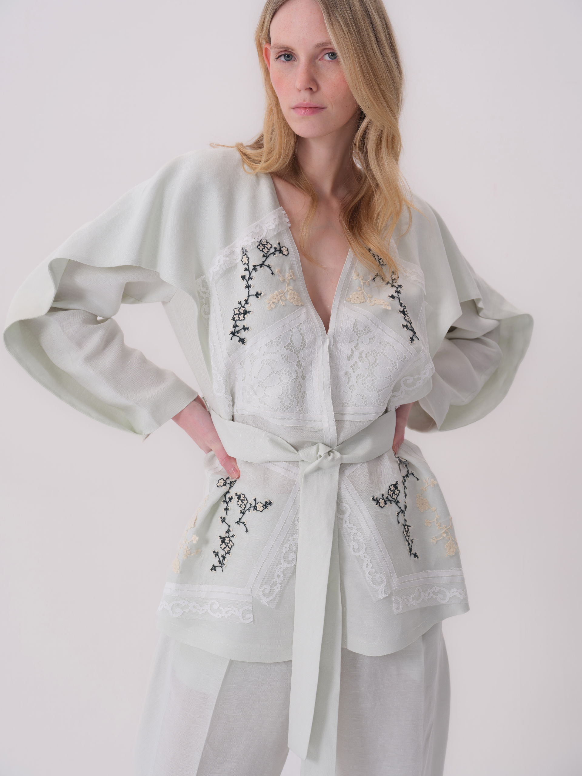 Mint green kimono jacket with wide sleeves, V-neck, white lace, black and cream floral embroidery, and a fabric belt.