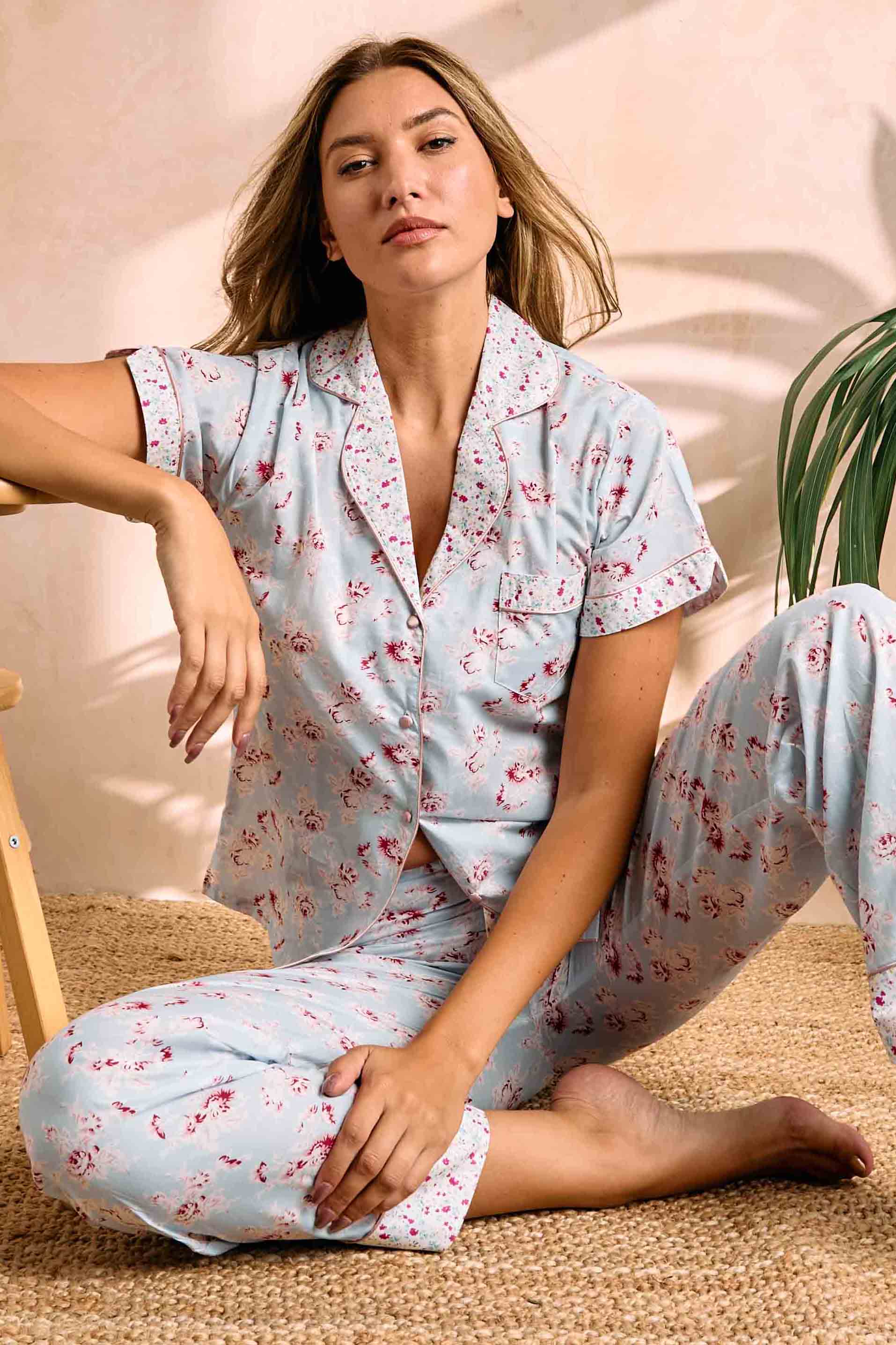 Pajama set: light blue with red rose floral print. Short-sleeved top has notched collar, chest pocket, pink piping. Matching