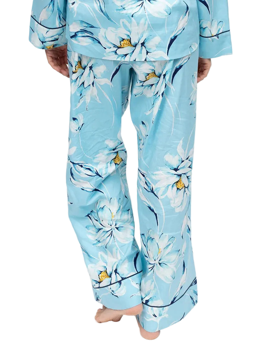 Light blue woven trousers with a white, yellow, and dark blue floral print. Loose-fitting, wide-leg style with dark blue pipi