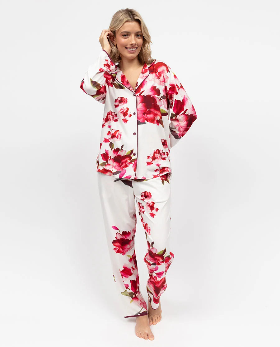 White jersey pyjama set with red and pink floral print. Long-sleeved button-front top with collar and ox blood piping. Matchi