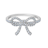 Silver-toned ring with a bow design, entirely encrusted with clear, brilliant-cut simulated diamonds.