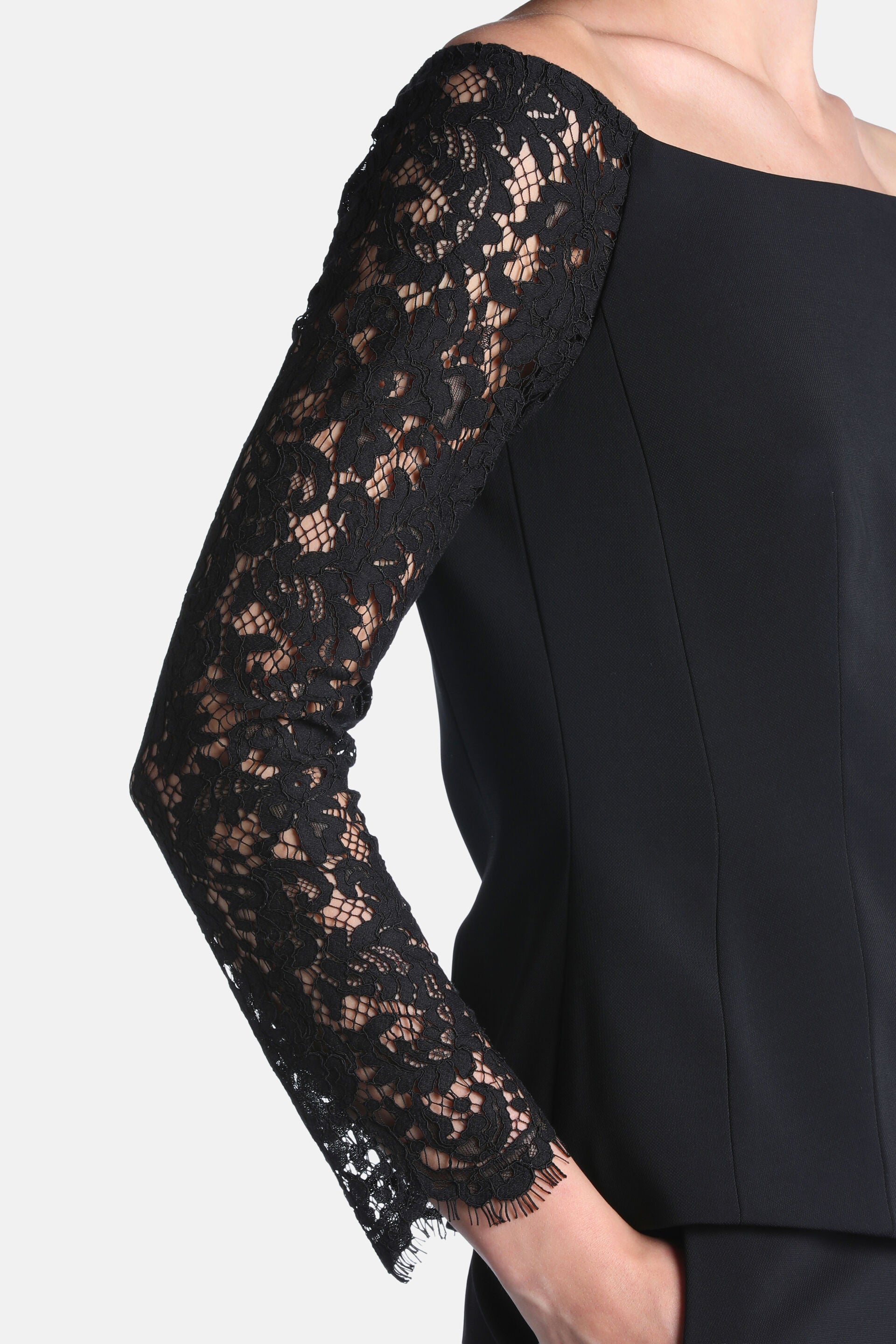 Black top with a wide neckline and long sheer black floral lace sleeves.