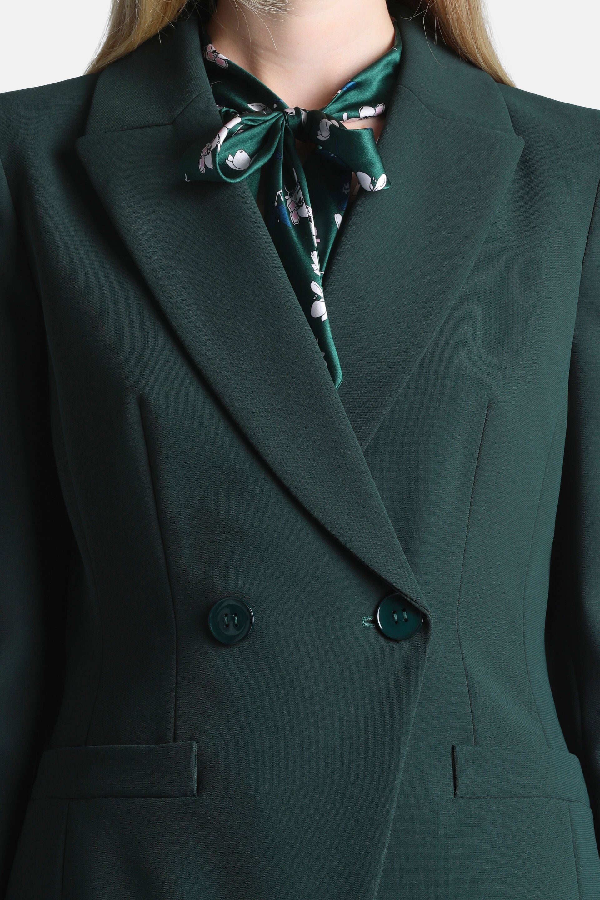 Dark green double-breasted blazer with notched lapels, two dark green buttons, and two front flap pockets.