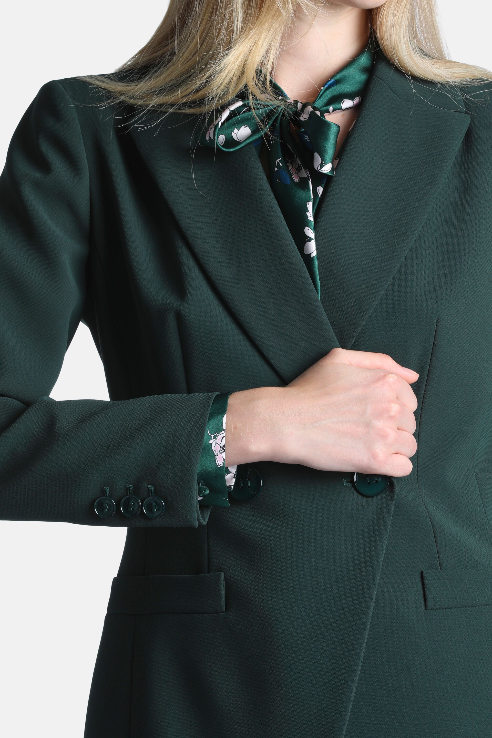 Deep green blazer with notched lapels, one dark front button, three dark cuff buttons, and two flap pockets.
