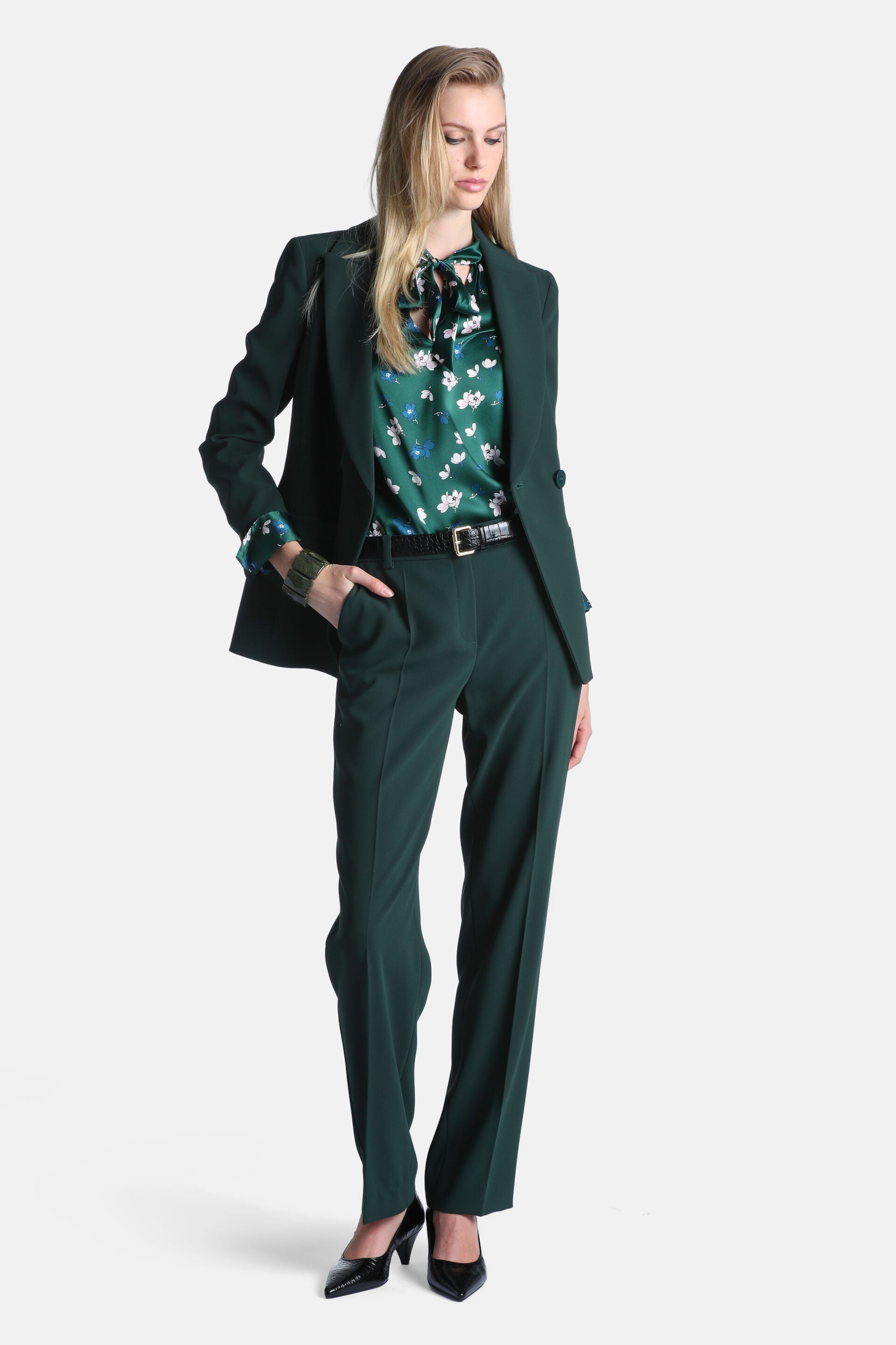 Dark green single-breasted blazer with notched lapels, two front buttons, and flap pockets.