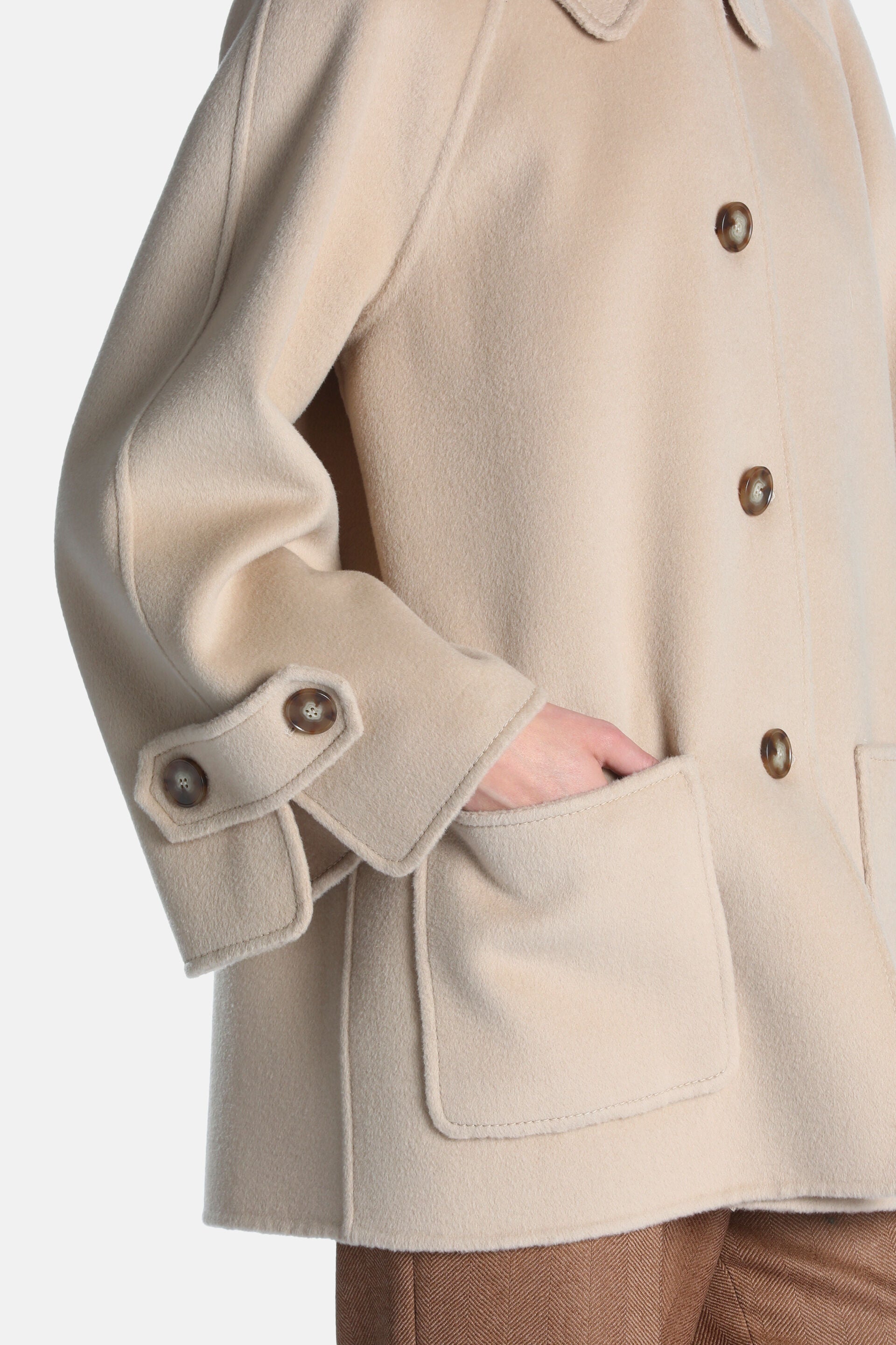 Light beige wool-blend coat with a rounded collar, three brown front buttons, buttoned cuff tabs, and two large patch pockets