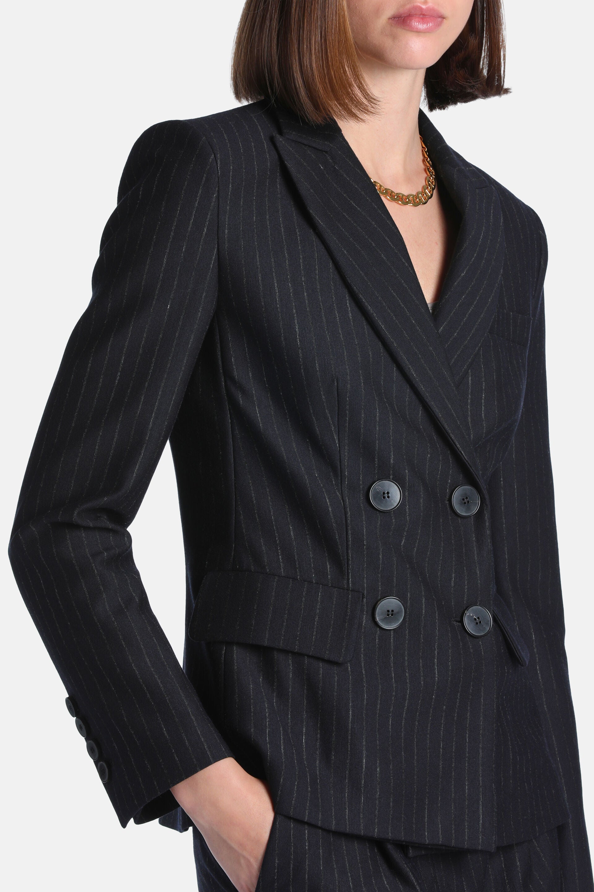 Dark blue pinstriped double-breasted blazer with notched lapels, four front buttons, three cuff buttons, and two flap pockets