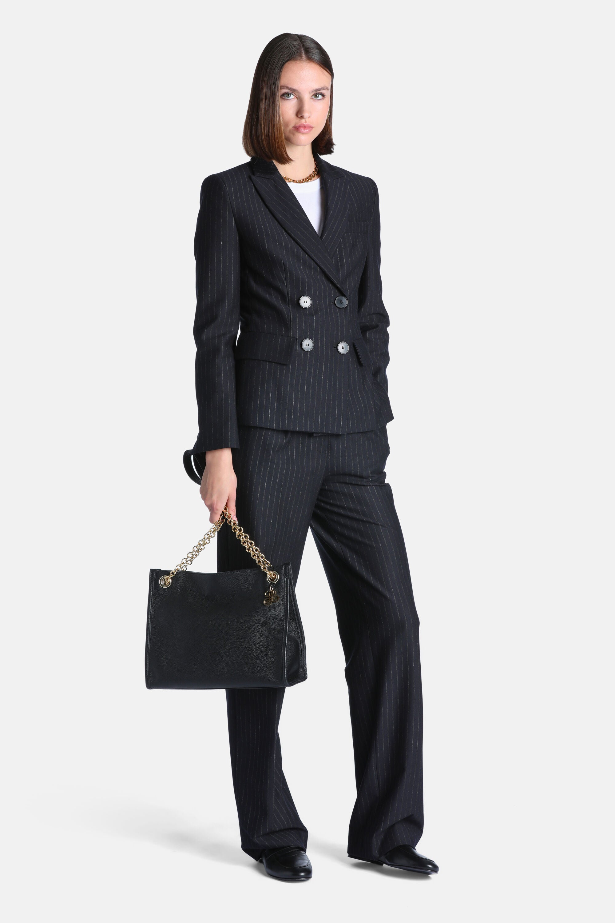 Dark blue pinstripe double-breasted blazer with notched lapels, four light-colored front buttons, and two flap pockets.