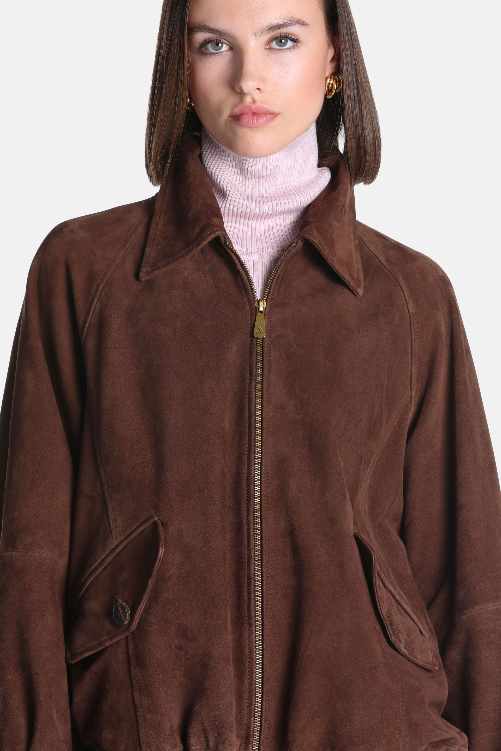 Brown suede leather jacket with a pointed collar, gold-toned full-zip front, raglan sleeves, and two front flap pockets, one