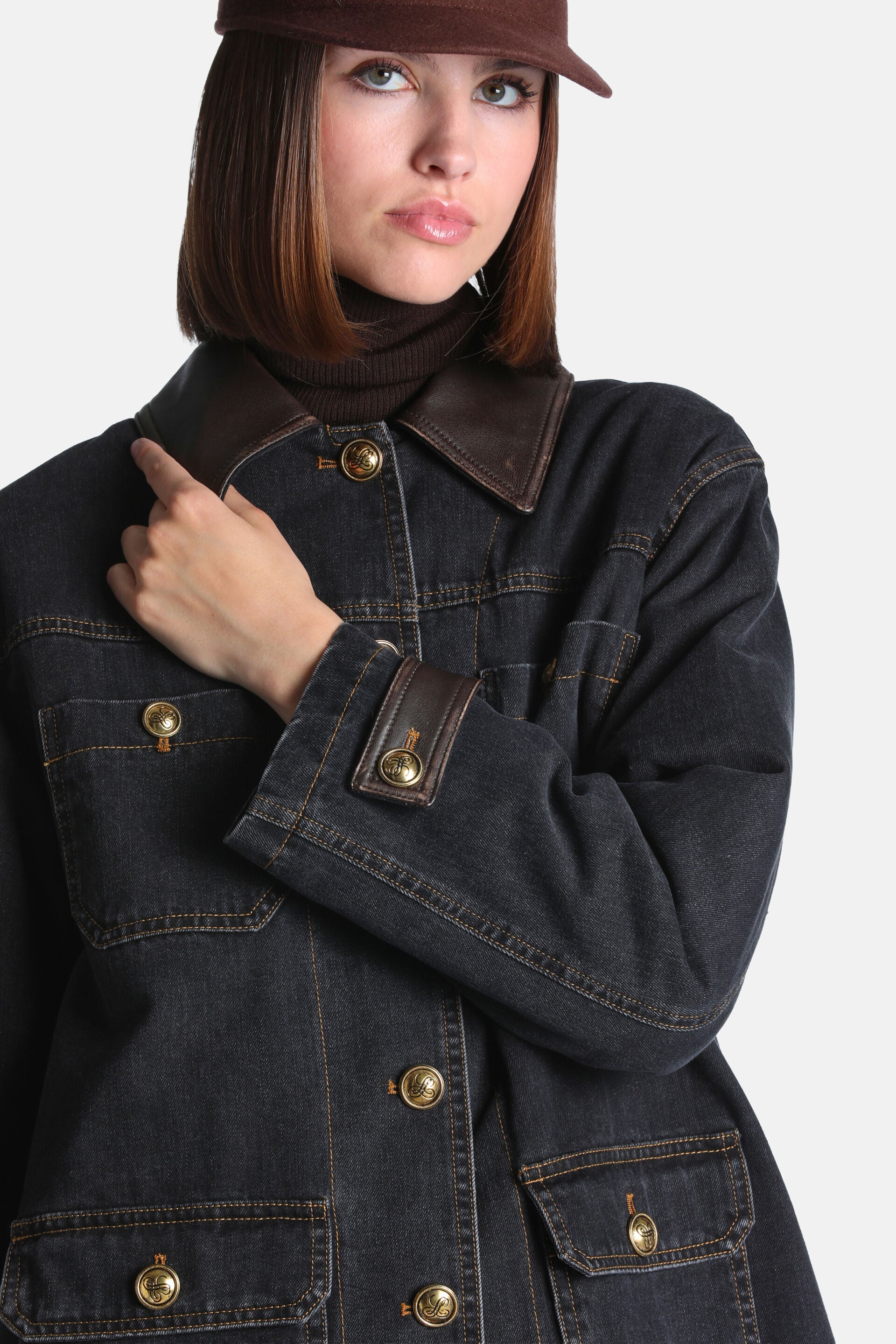 Black denim coat with brown leather-look collar and cuffs. Features contrasting brown stitching and gold-toned embossed butto