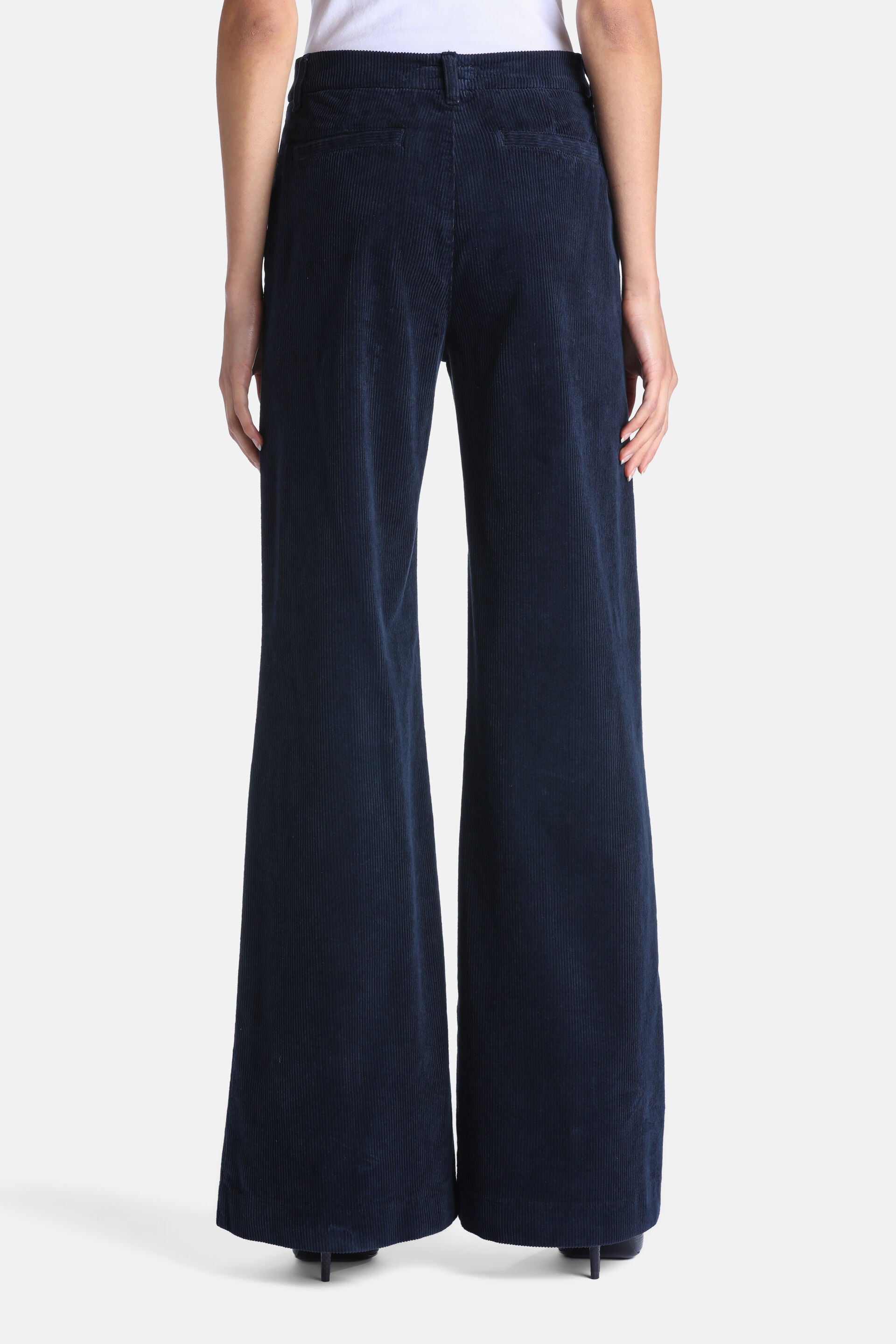 Navy blue corduroy trousers with a high-waisted, wide-leg cut, viewed from the back.