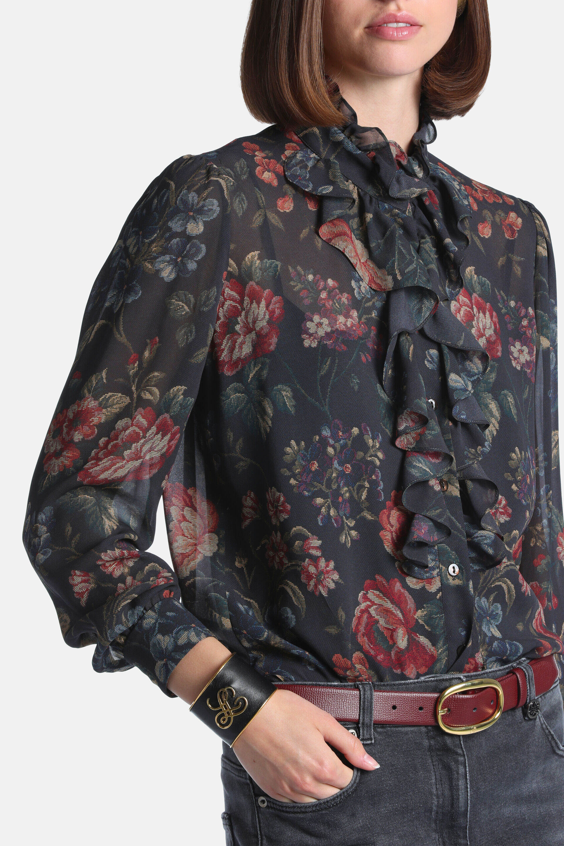 Dark brown sheer floral blouse with red, blue, purple flowers, a ruffled collar, ruffled front placket, and ruffled cuffs.