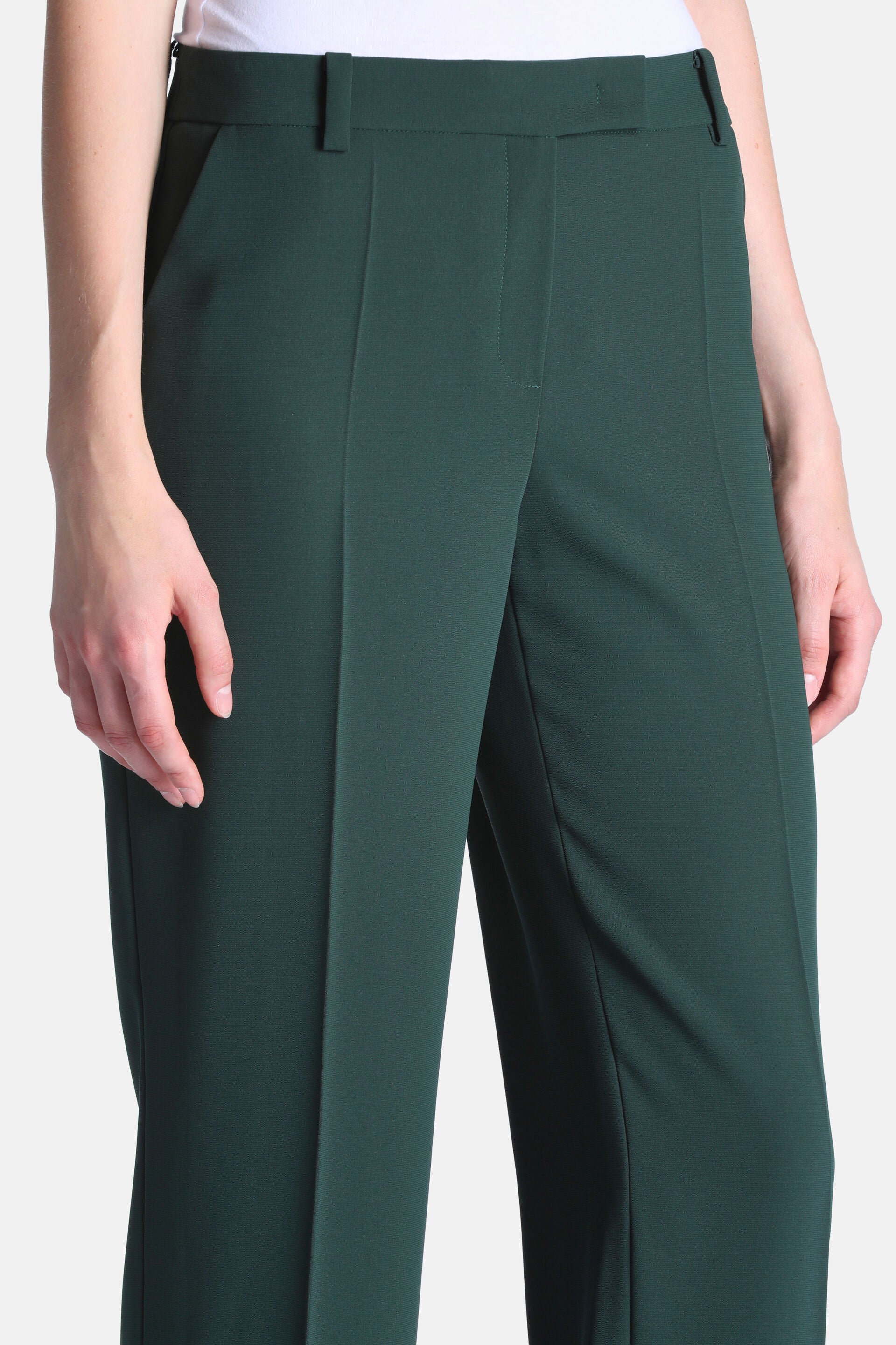 Dark green high-waisted trousers with belt loops, a flat front, concealed zip, side slash pockets, and front leg creases.