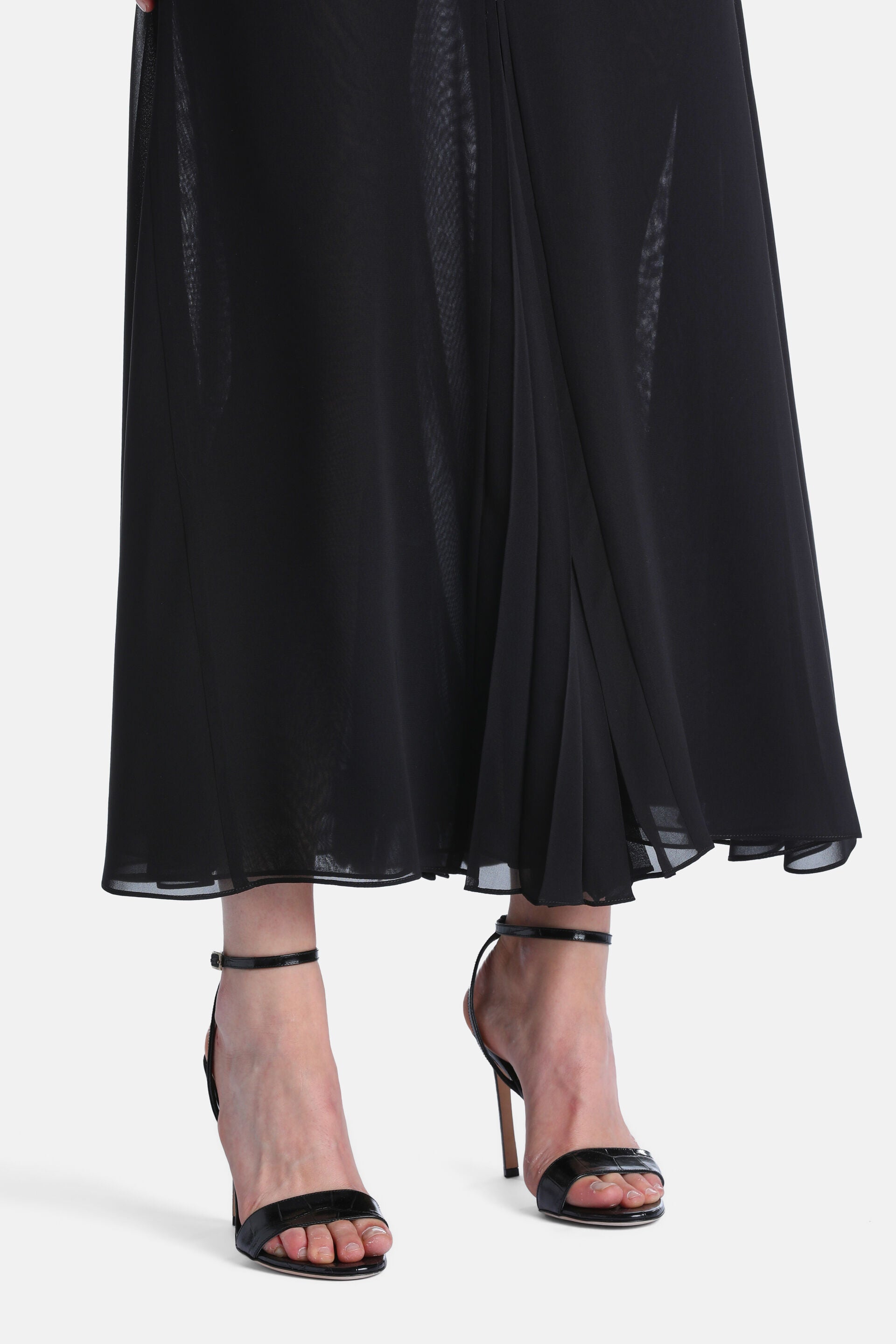 Black ankle-length skirt with a sheer outer layer over an opaque lining, featuring a pleated panel on the right.