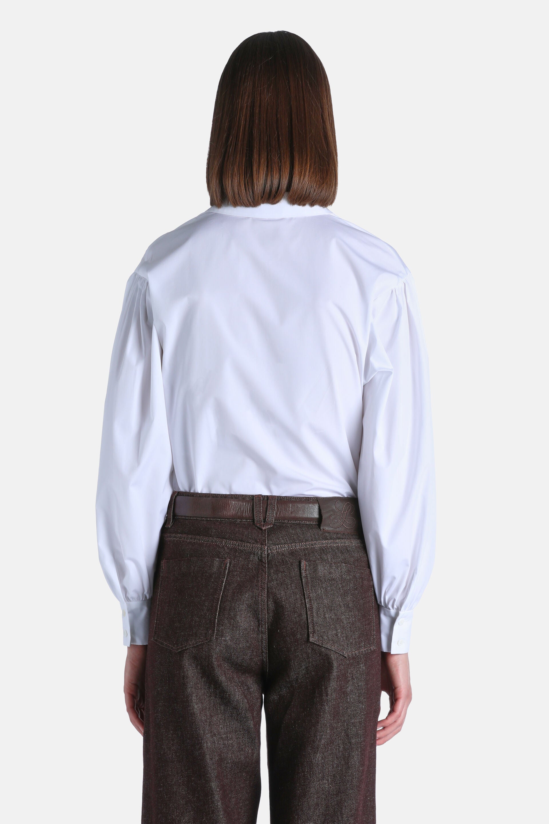 White shirt with a high collar, long full sleeves with cuffs, and a back yoke, viewed from the back.