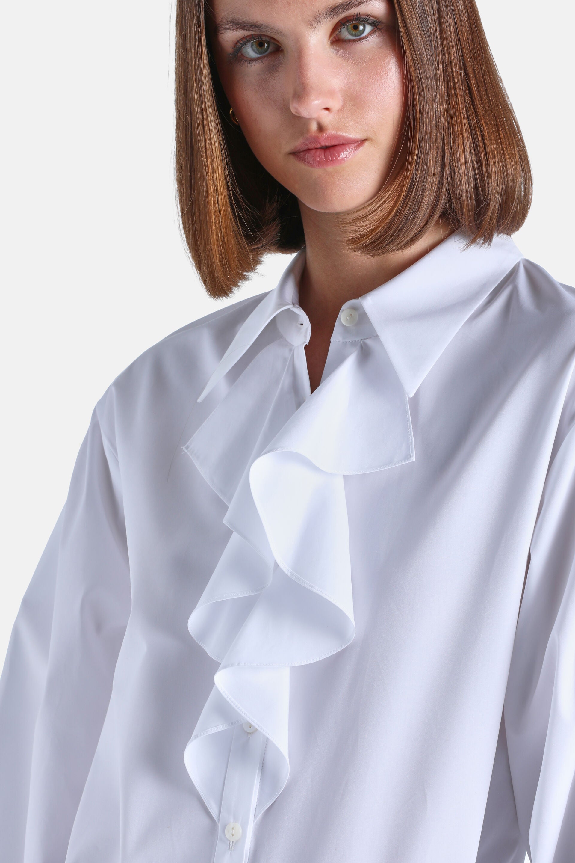 White collared shirt with a prominent vertical ruffle down the front and light-colored buttons.