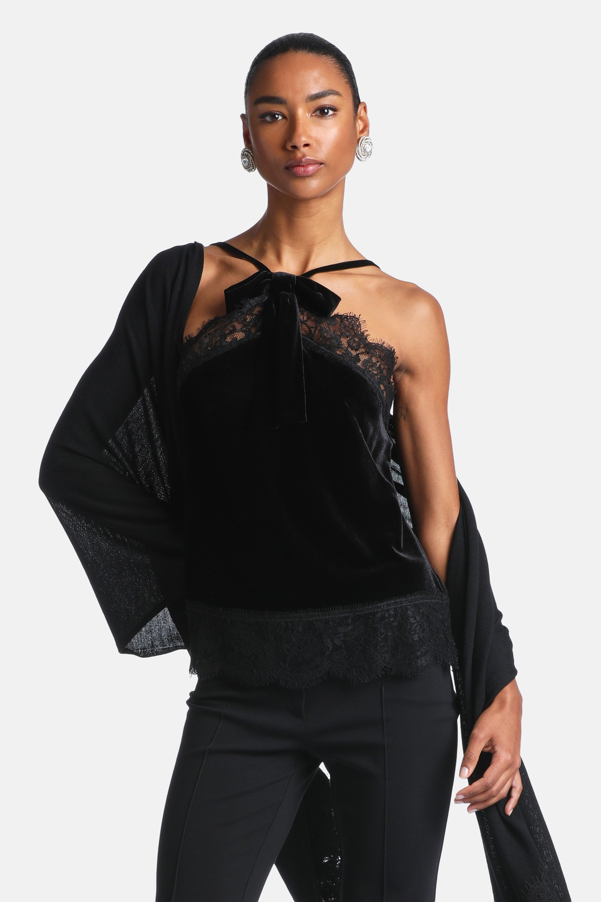 Black velvet camisole top with a sweetheart neckline, black lace trim along the neckline and hem, and a velvet bow at the fro